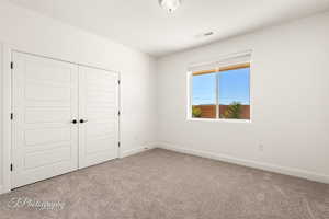Unfurnished bedroom with carpet floors and a closet