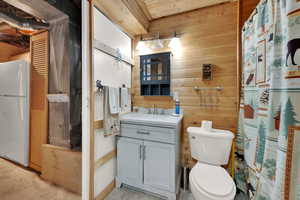 Bathroom featuring wooden walls, curtained shower, vanity, light tile patterned flooring, and wooden ceiling