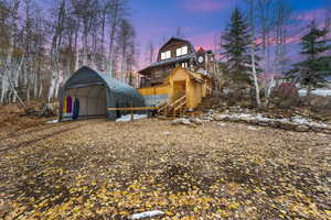 Rear view of house featuring stairway and a deck