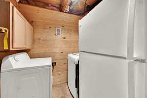 Laundry area with wood walls and washing machine and dryer