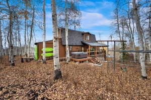 Back of house with roof with shingles and a wooden deck