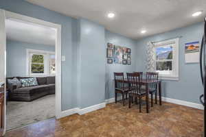 Dining area featuring a textured ceiling and recessed lighting