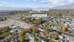 Aerial view of property and surrounding area with nearby suburban area and mountains