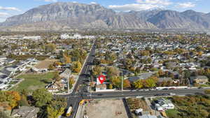 Aerial view of property's location with nearby suburban area and a mountainous background