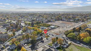 Aerial view of property and surrounding area with a mountain backdrop and nearby suburban area