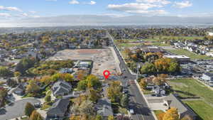 Aerial view of property and surrounding area with nearby suburban area and a mountainous background