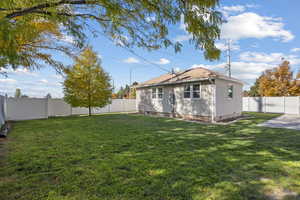 Back of property with a fenced backyard and crawl space