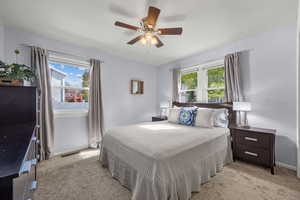 Bedroom with light carpet and a ceiling fan