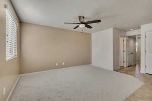 Unfurnished bedroom featuring ceiling fan, light carpet, and light tile patterned floors