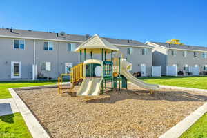 Community play area with a lawn and a residential view