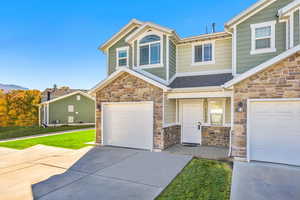 Craftsman-style home with stone siding, concrete driveway, a garage, and a shingled roof