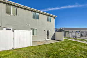 Back of house featuring stucco siding and a gate