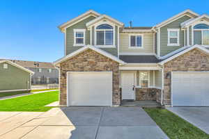 Craftsman inspired home with stone siding, concrete driveway, and a garage