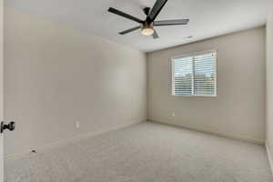 Spare room with carpet and ceiling fan