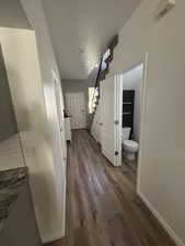 Hallway with stairs and dark wood-type flooring