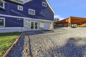 Back of house featuring board and batten siding and a carport
