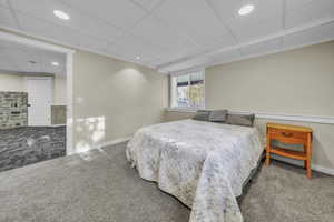Carpeted bedroom with a drop ceiling and recessed lighting