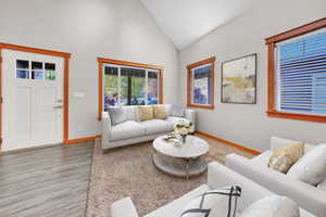 Living area with high vaulted ceiling and wood finished floors