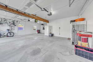 Garage featuring freestanding refrigerator and a garage door opener