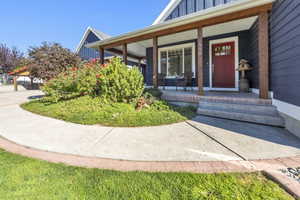 Doorway to property with board and batten siding and a porch