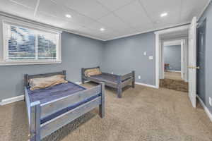 Bedroom with light colored carpet, a paneled ceiling, and recessed lighting