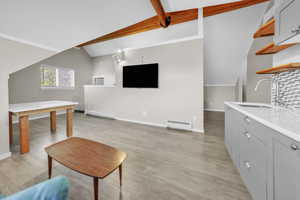 ADU above the garage. Living room featuring baseboard heating and light wood-style flooring