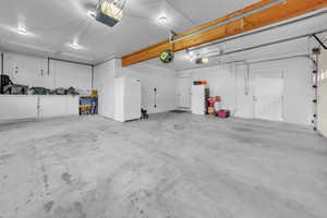 Garage featuring white fridge and a garage door opener