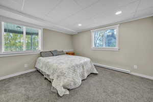 Bedroom with a baseboard radiator, carpet floors, a paneled ceiling, and recessed lighting