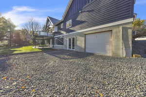 View of property exterior featuring board and batten siding, a wooden deck, french doors, and a garage