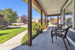 Covered porch featuring a yard