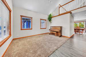 Unfurnished room featuring high vaulted ceiling and wood finished floors