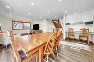 Dining area featuring recessed lighting, light wood-style flooring, stairway, and a desk