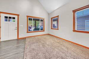 Entrance foyer with high vaulted ceiling and light wood-type flooring