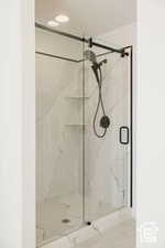 Bathroom featuring a marble finish shower