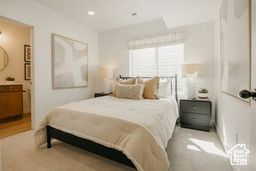 Bedroom featuring ensuite bathroom and carpet