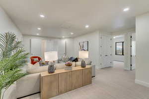 Living room featuring light carpet, recessed lighting, and attic access