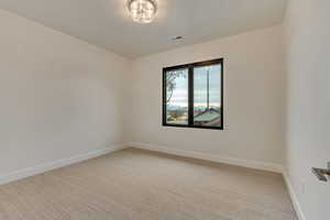 Unfurnished room featuring light carpet
