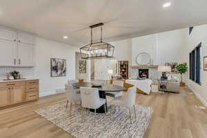 Dining area with recessed lighting, light wood-style floors, a fireplace, and stairway