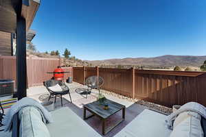 Fenced backyard with a patio, an outdoor hangout area, and a mountain view