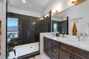 Full bath featuring double vanity, a stall shower, and light tile patterned flooring