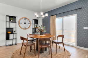 Dining area with light wood-style flooring and a chandelier