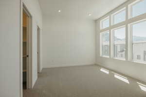 Spare room featuring light carpet, a mountain view, and recessed lighting