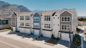 Back of house featuring a residential view, driveway, a mountain view, and an attached garage