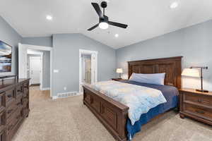 Bedroom featuring lofted ceiling, light colored carpet, a ceiling fan, ensuite bath, and recessed lighting