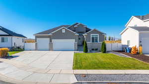 Craftsman house with stucco siding, driveway, a garage, a gate, and stone siding