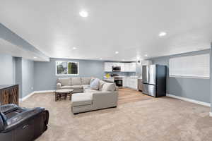 Living area featuring light colored carpet and recessed lighting