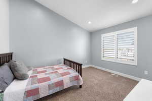 Carpeted bedroom featuring recessed lighting and lofted ceiling