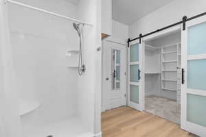 Primary bathroom and closet with barn doors