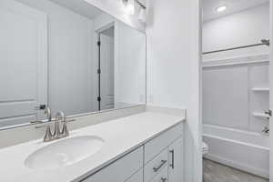 Bathroom with vanity, tub / shower combination, and light tile patterned flooring