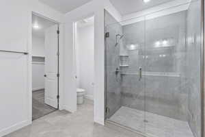 Full bathroom with a shower stall, a walk in closet, and light tile patterned floors